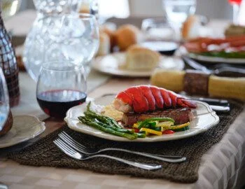 close-up image of steak and lobster dinner with wine