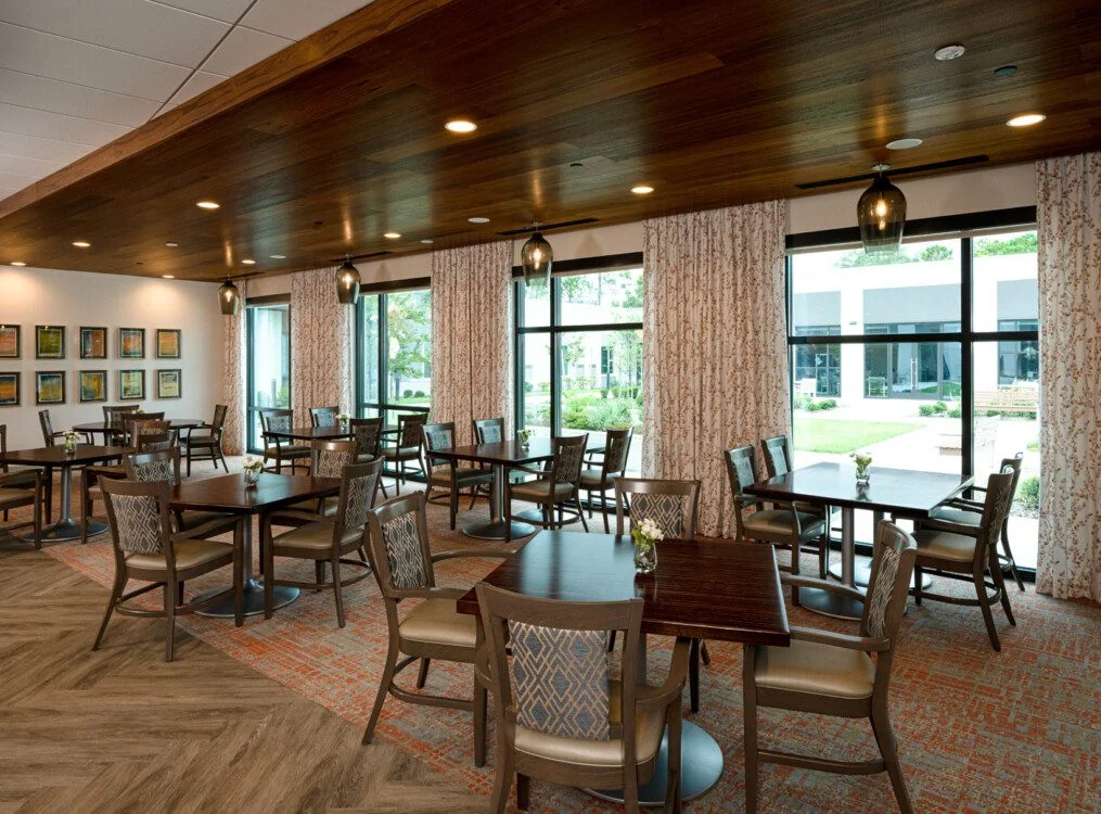 expansive indoor dining area with table and chairs at Village on the Green Senior Living Community