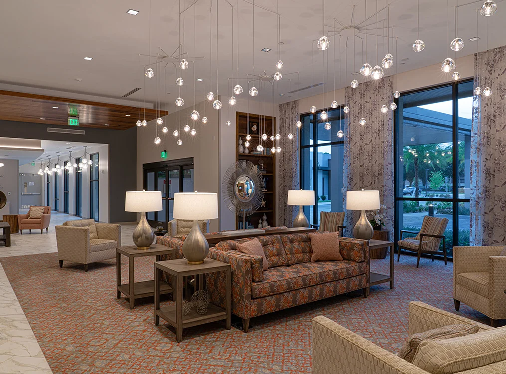 Spacious, elegantly lit lobby with modern furniture and large windows.