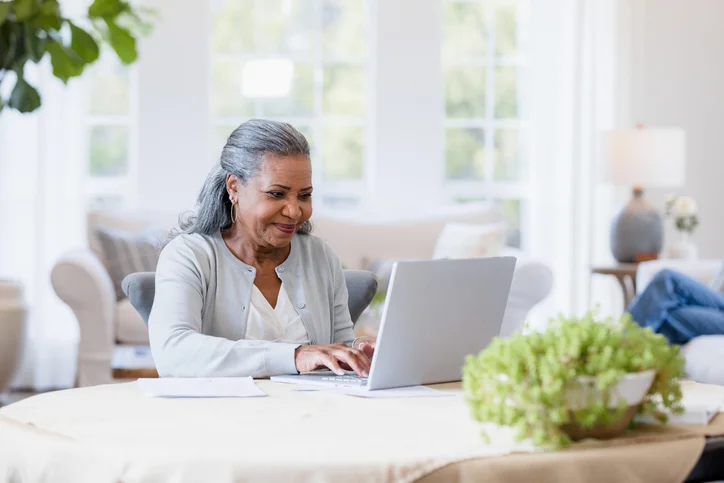 The mother sits at her computer answering emails to her friends.