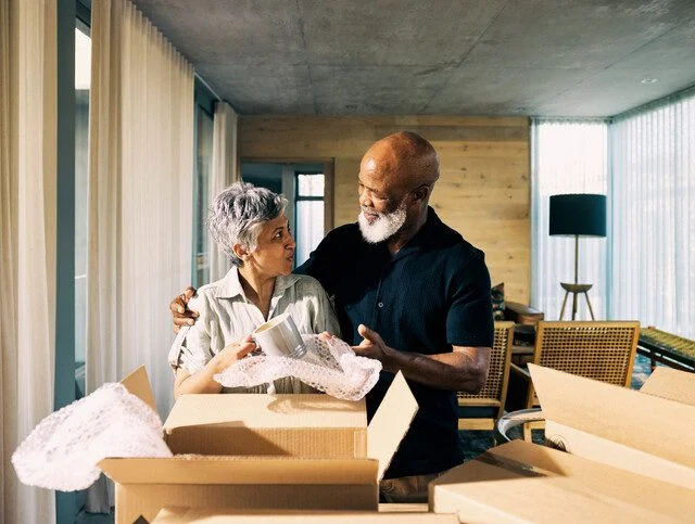 Generation X African-American Couple Unpacking Memories and Smiling in New Home During Retirement Transition