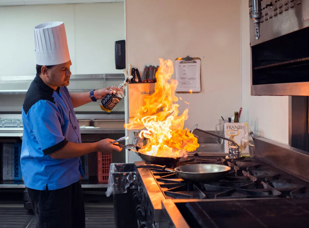 Chef in a kitchen cooking with fire