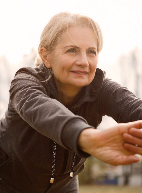 Senior woman stretches in preparation for a jog outdoors