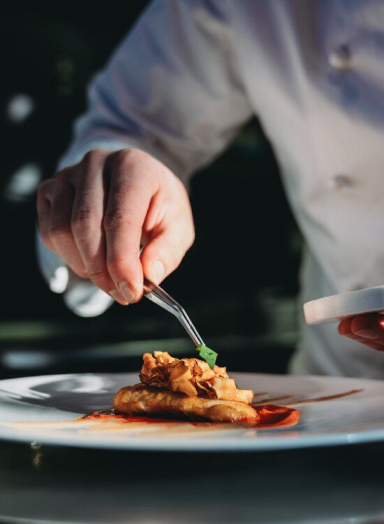 close-up of chef carefully plating elegant meal