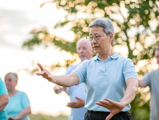 group of seniors practice Tai Chi outdoors