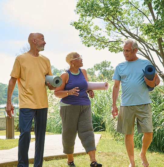 close-up of three seniors walking back after an outdoor yoga session