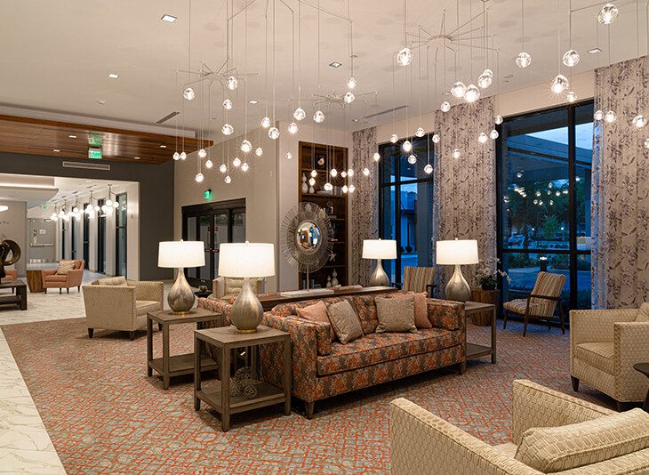 Modern and elegant waiting lounge with seating and hanging orb lights at Village on the Green