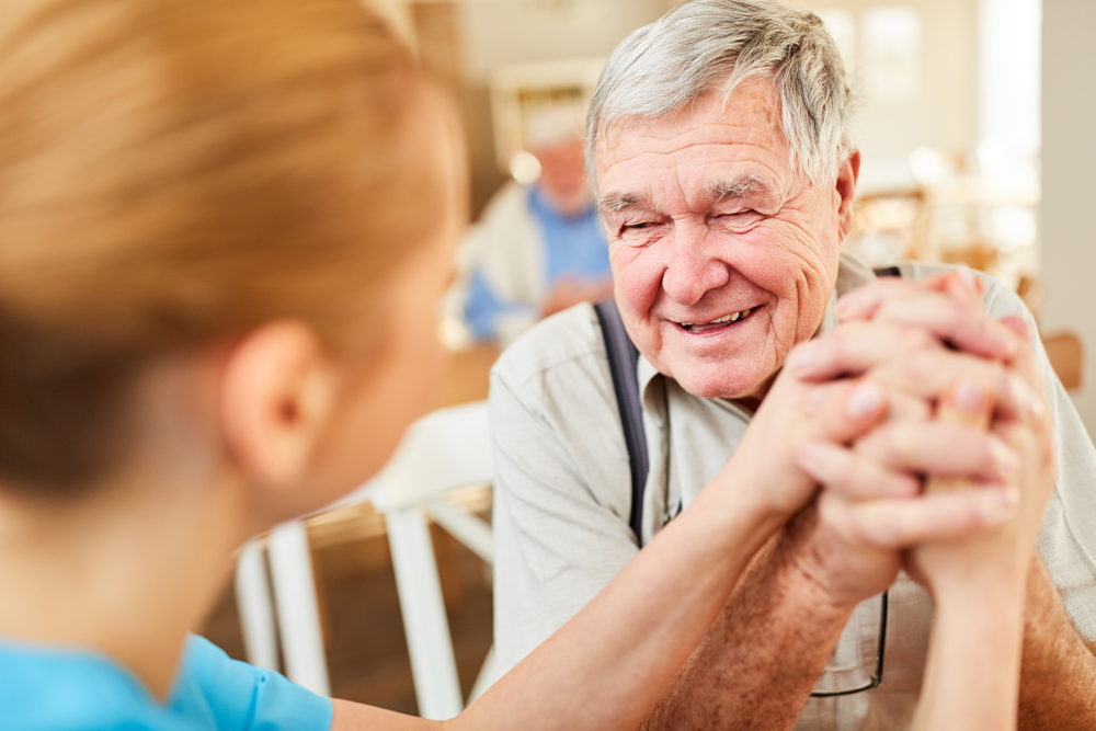 Senior man holding hands with a caregiver