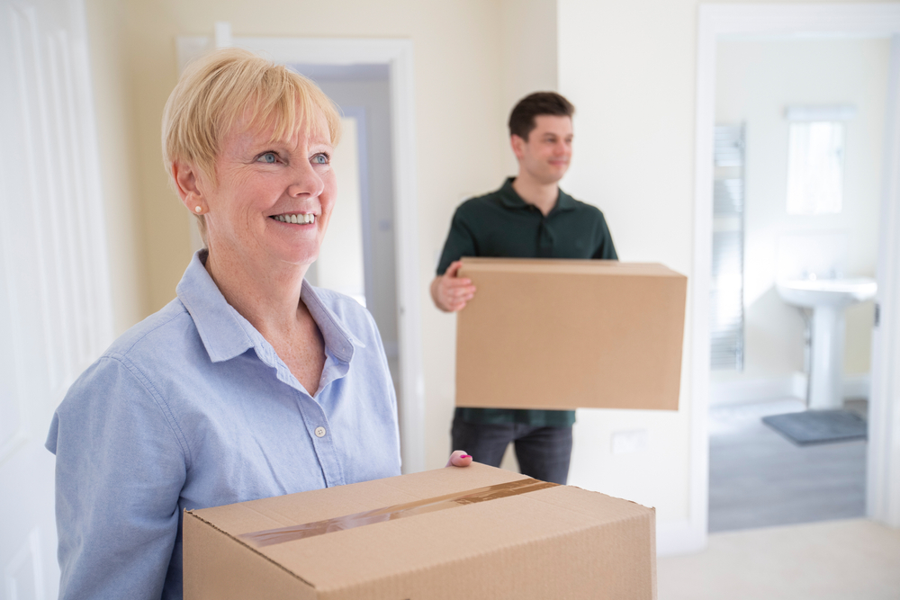 Senior woman and son holding moving boxes