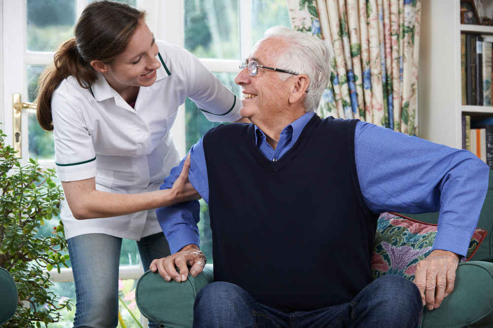 Senior man being helped up by a nurse