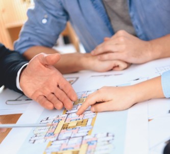 close-up of hands examining a printed floor plan