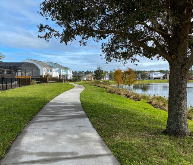 scenic waterfront walking path during the fall at Village on the Green Senior Living Community