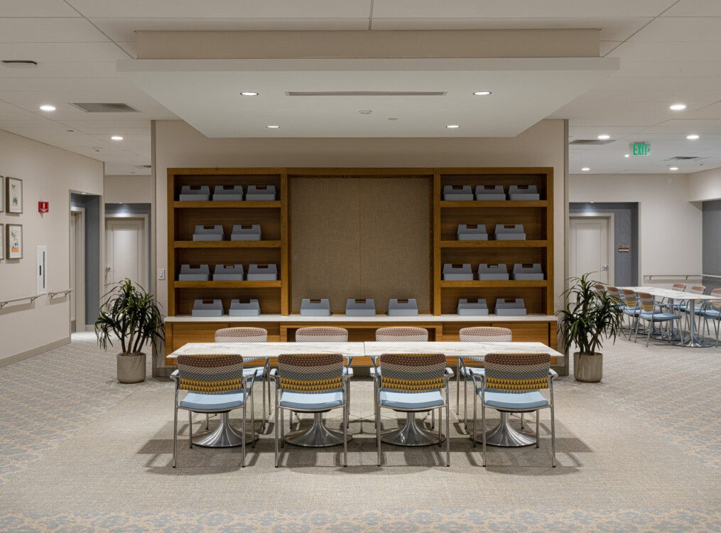 conference room with long rectangular tables and chairs at Village on the Green Senior Living Community