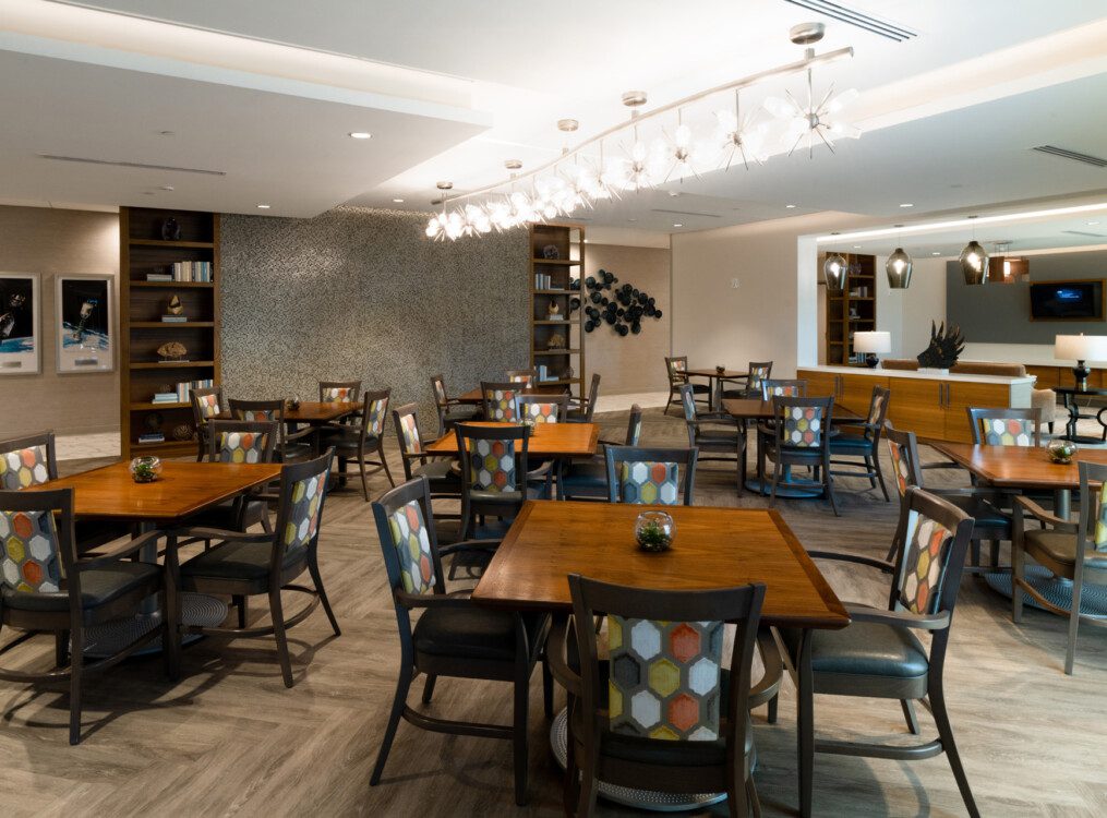 Expansive indoor dining area with tables and chairs at Village on the Green Senior Living Community