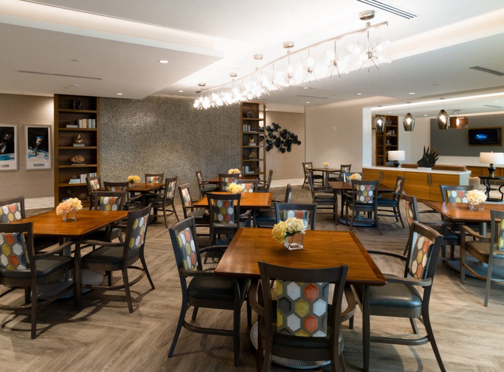 expansive indoor dining area with table and chairs at Village on the Green Senior Living Community