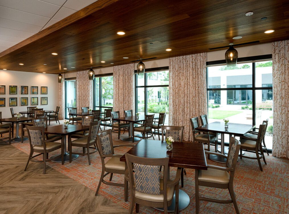 expansive indoor dining area with table and chairs at Village on the Green Senior Living Community