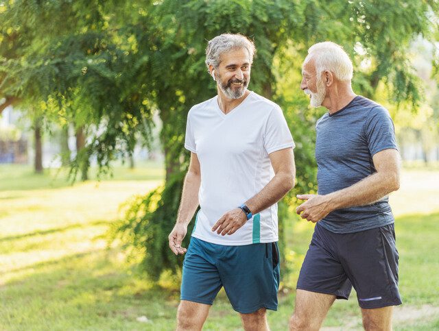 Two senior men talking and exercising together