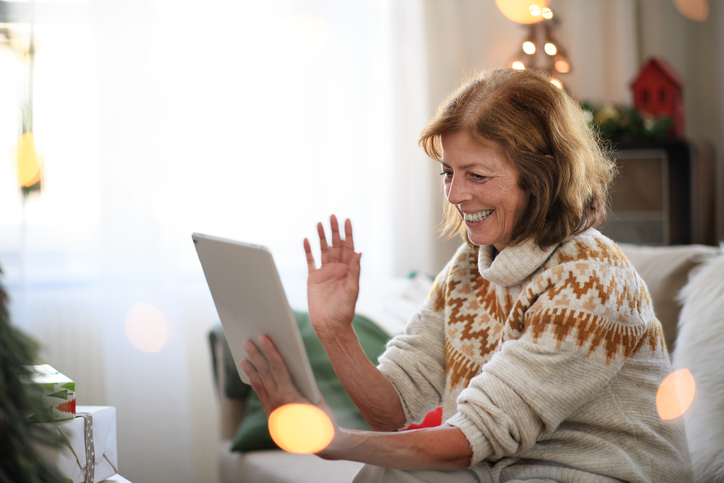 Senior woman smiling as she talks via video chat on her tablet.