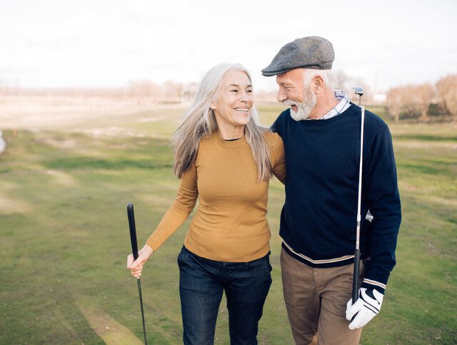 Happy senior couple enjoying a day of golf in their community.