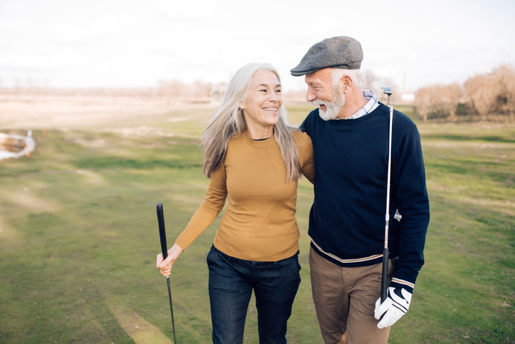 Happy senior couple enjoying a day of golf in their community.